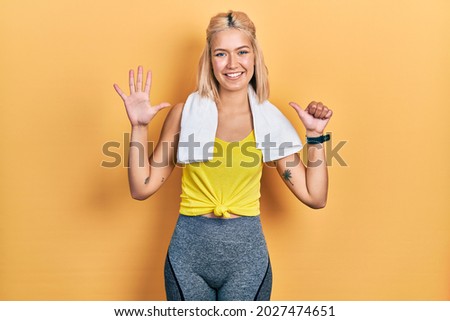 Beautiful blonde sports woman wearing workout outfit showing and pointing up with fingers number six while smiling confident and happy. 