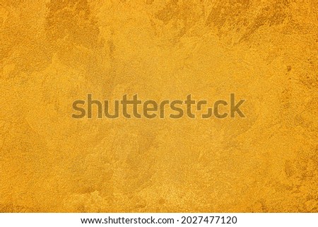 Texture of golden decorative plaster or concrete. Abstract grunge background for design. Royalty-Free Stock Photo #2027477120