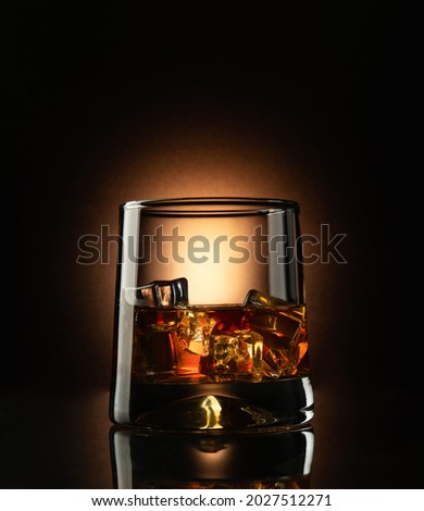 Whiskey with ice in a glass on a dark background. Selective focus Royalty-Free Stock Photo #2027512271
