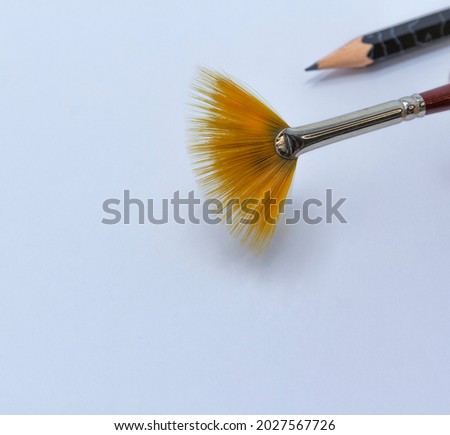 fan-shaped art brush and pencil on a white background, copy space, back to shool