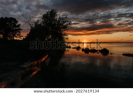 Photo of a Summer Sunset on the Lake. Travel location of popular tourist outdoor. View of beautiful Sea Landscape. Relax vacation near water