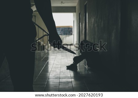 Violent man carries a knife attempting to attack a young woman in front of the room.Domestic violence problems Concept.
 Royalty-Free Stock Photo #2027620193