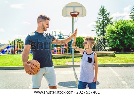 A Happy basketball family portrait play this sport on summer season. The father play with boy