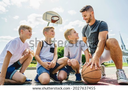 A Happy basketball family portrait play this sport on summer season. The father play with boy
