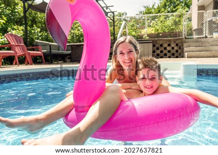 A mother and son having fun in swimming pool