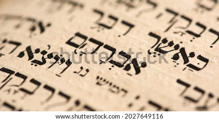 Closeup of hebrew word in Torah page that translates in english as Abraham, common patriarch of religions. Selective focus. Banner Royalty-Free Stock Photo #2027649116
