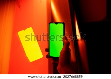 
man's hand showing cell phone screen to camera at night in exteriors