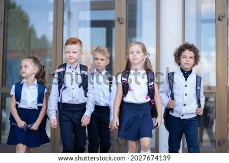 A group of little schoolchildren leave the school building after lessons Royalty-Free Stock Photo #2027674139