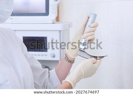 Apparatus for tracheal intubation in the hands of an anesthesiologist, resuscitator. Hands in protective gloves. Preparing for surgery. A device for artificial lung ventilation.Copy space.