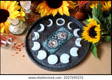 Beautiful dark plate with moon phases and tarot card, wiccan altar, witchraft Royalty-Free Stock Photo #2027690231
