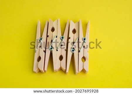 Wooden clothespins for drying clothes on a yellow background.