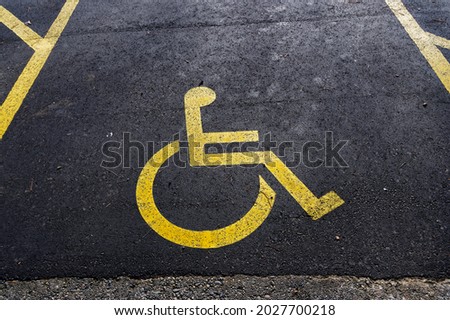 Disabled parking is marked with a yellow disabled sign painted on the road