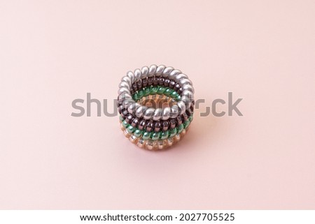 Stack of colorful elastic bands for hair. Pink background