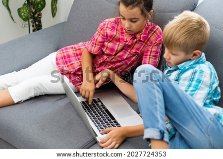 Cute children use laptop for education, online study, home studying, Boy and Girl have homework at distance learning. Lifestyle concept for home schooling.