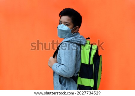 Indonesian boys wearing medical masks get ready to go to school