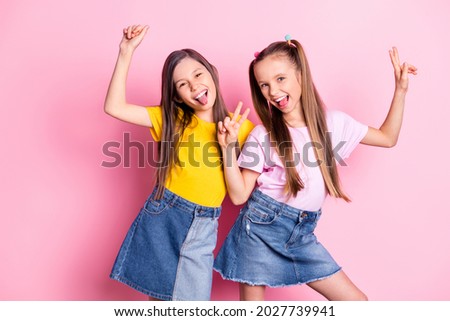Photo of optimistic brunette blond girls show v-sign wear yellow pink t-shirt skirts isolated on pink color background