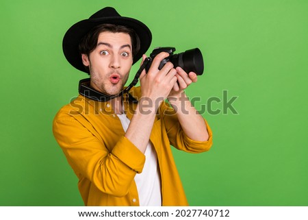 Photo of young shocked amazed cameraman take picture shooting good picture isolated on green color background
