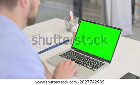 Young Man Using Laptop with Green Screen 