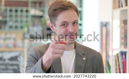 Portrait of Young Man Pointing at Camera