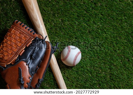 Baseball and wood bat with mitt on grass field overhead view Royalty-Free Stock Photo #2027772929