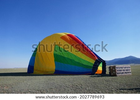 Deflated rainbow colored hot air balloon laying on side Royalty-Free Stock Photo #2027789693
