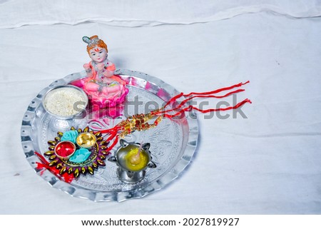 Indian festival: Raksha Bandhan background with an elegant Rakhi, Rice Grains and Kumkum.