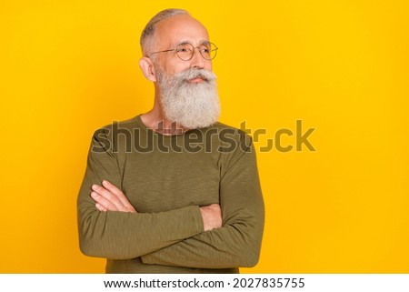 Photo of confident smart old man crossed hand look empty space wear specs green shirt isolated yellow color background