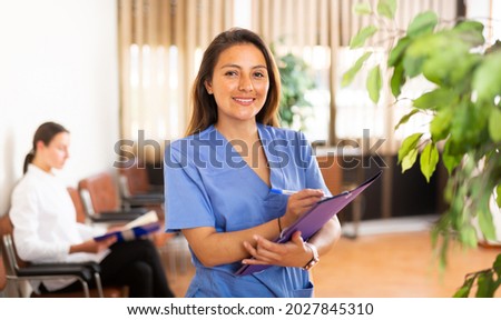 Portrait of confident smiling woman medical worker standing in clinic office Royalty-Free Stock Photo #2027845310