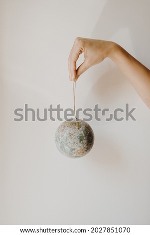 Globe model in female hand on white background. Save the world, planet Earth concept. Women's rights and power concept