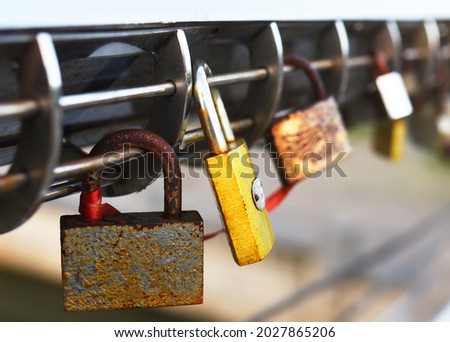Padlock on Lovers Lock Bridge. Husband and wife during the wedding hung a padlock on the fence on metal grate. Love locks concept. Many a padlock are locked with a key for the happiness of people