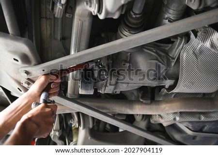 Rear differential fluid change in garage service shop. Royalty-Free Stock Photo #2027904119