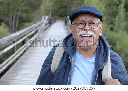 Ethnic senior man walking outdoors Royalty-Free Stock Photo #2027959259