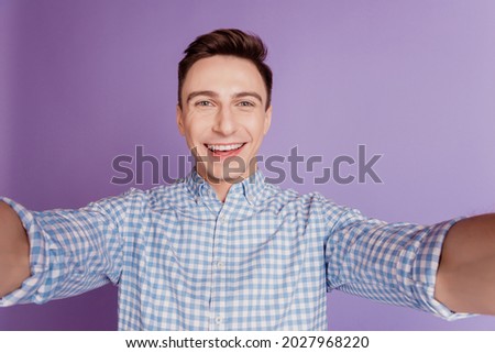 Portrait of positive handsome attractive guy take selfie beaming smile on violet background