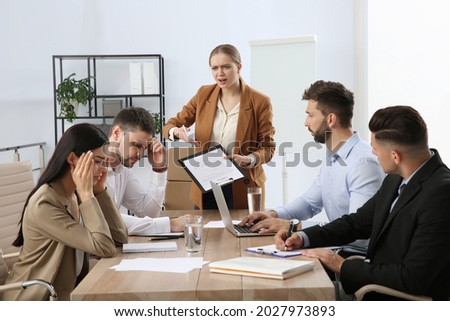 Boss screaming at employees in office. Toxic work environment Royalty-Free Stock Photo #2027973893