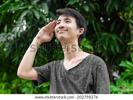 young asia man saluting sign in a natural at outdoor sunrise