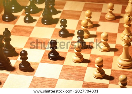 Wooden chessboard with game pieces as background