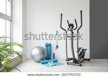 Different sports equipment and fitness ball in gym Royalty-Free Stock Photo #2027992703