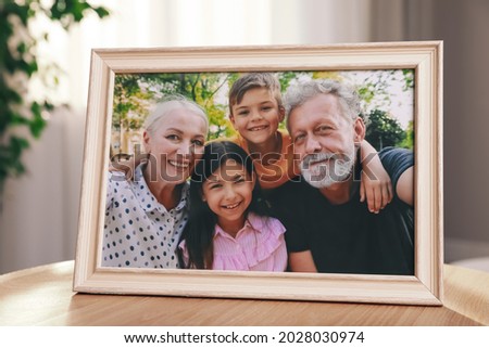 Framed family photo on wooden table in room