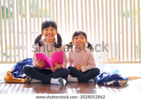 Cute little girl reading books at home. She has a look of enjoyment on her face and she looks very relaxed. Which increases the development and enhances learning skills outside the room.

