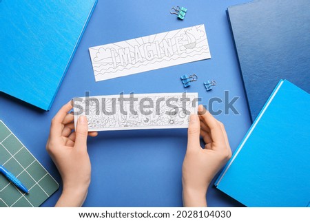 Female hands with cute bookmarks on color background