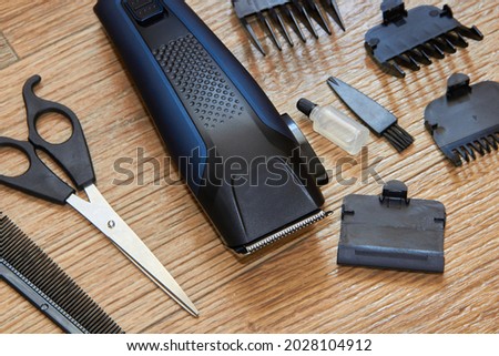 hair clipper with nozzles,haircut tools on wooden background Royalty-Free Stock Photo #2028104912