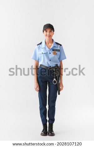 Female police officer on light background