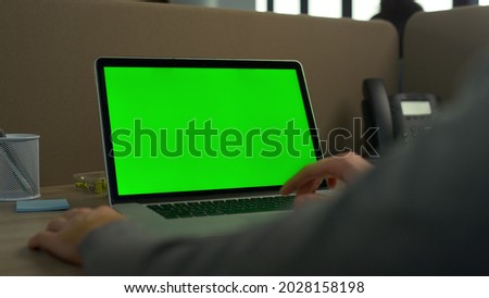 Businessman hands using laptop green screen in office. Unrecognizable professional working on computer green screen. Closeup man fingers scrolling trackpad on laptop chroma key at workplace