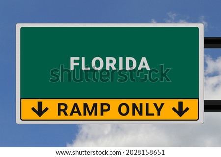 Florida logo.  Florida lettering on a road sign. Signpost at entrance to  Florida, USA. Green pointer in American style. Road sign in the United States of America. Sky in background