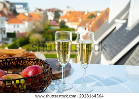 Drinking of brut champagne sparkling wine in flute glasses on outdoor cafe or bistro terrace in France on sunny day