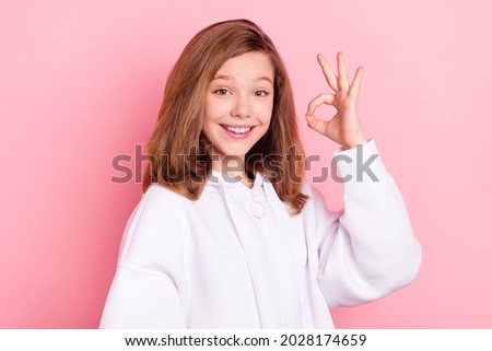 Portrait of attractive cheerful girl showing ok-sign ad advert good solution isolated over pink pastel color background