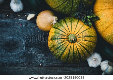 Gardening organic vegetables in assortment, buttercup squash, pumpkin and spices on wooden rustic board, top view with copyspace.