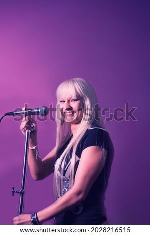 Close up photo beautiful funky blond lady on karaoke night hang out having fun playing rock star, casual black t-shirt over pink and violet background copyspace on top mock-up