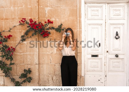 social network style picture of a young woman holding an old photo camera