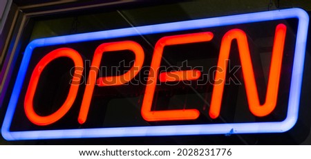 Blue and red neon open sign at night. Store, bar, business concepts